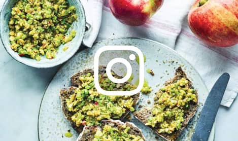 Plate of toast with peaches and a knife, with an Instagram logo on top in white.