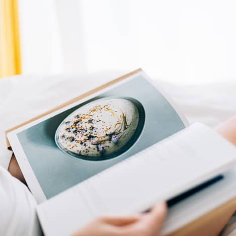 Recipe book perched in women's lap